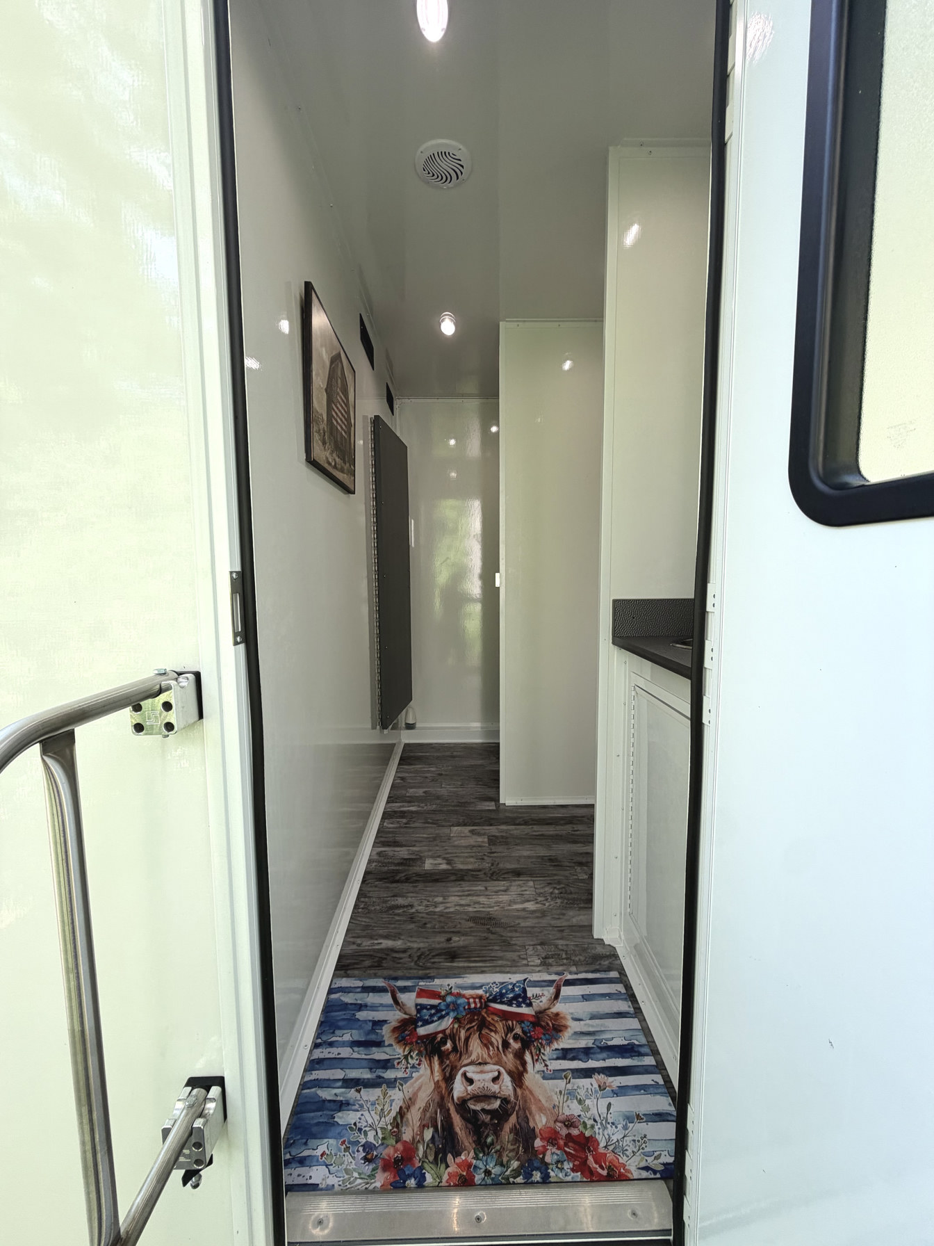 Entrance into luxury restroom trailer interior with wood-look flooring