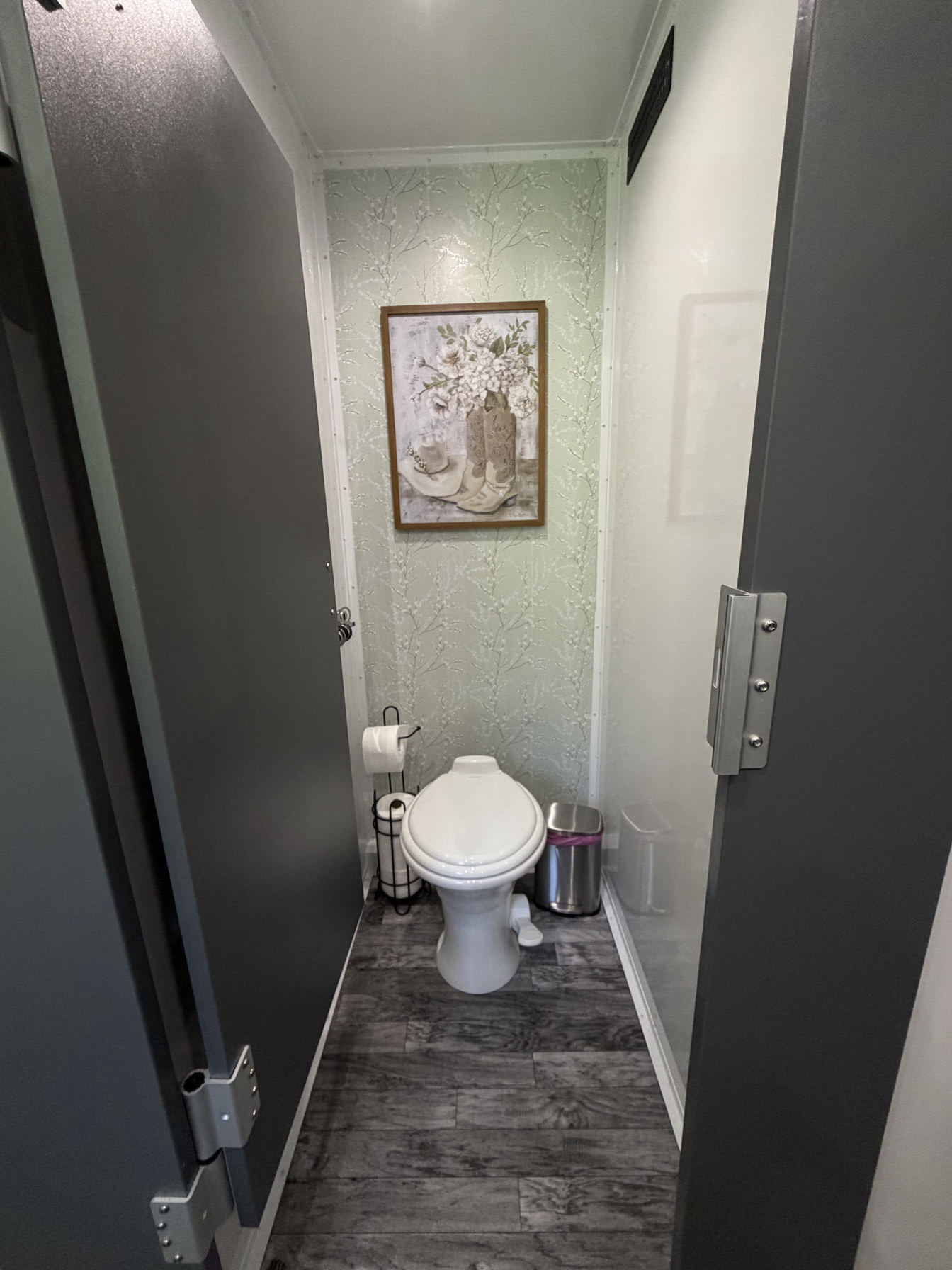Private stall with flushing toilet and solid door in restroom trailer